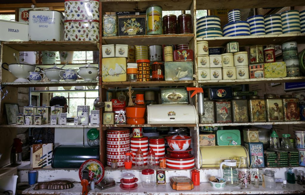 pexels-photo-35285902-35285902 A nostalgic look at a vintage kitchen with assorted tins and crockery on wooden shelves, evoking a classic charm.